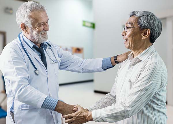 Doctor and patient smiling shaking hands